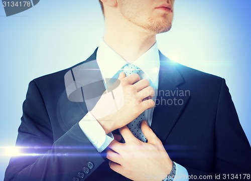 Image of man adjusting his tie