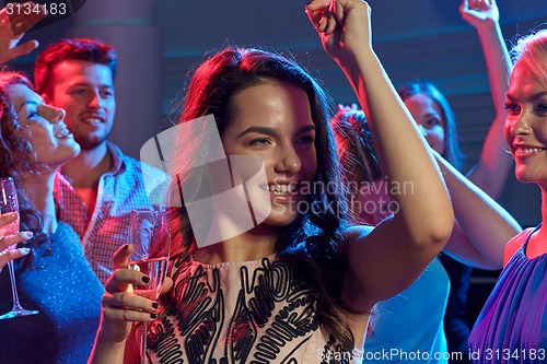 Image of smiling friends with glasses of champagne in club