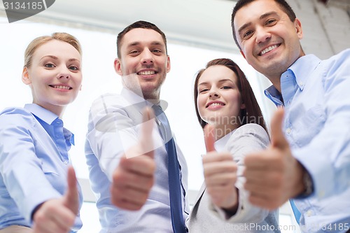 Image of smiling business people showing thumbs up