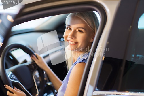 Image of happy woman inside car in auto show or salon