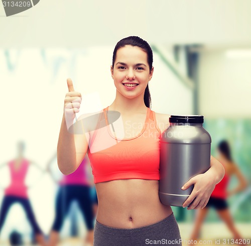 Image of teenage girl with jar of protein showing thumbs up