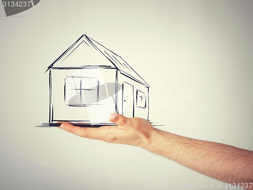 Image of house on virtual screen in man hand