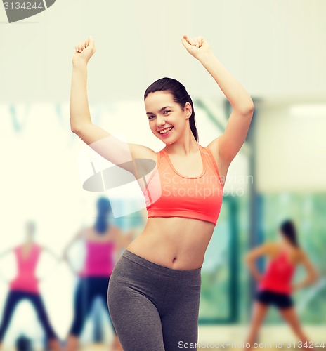 Image of smiling teenage girl in sportswear dancing