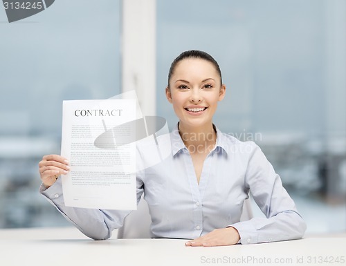 Image of happy businesswoman holding contract in office