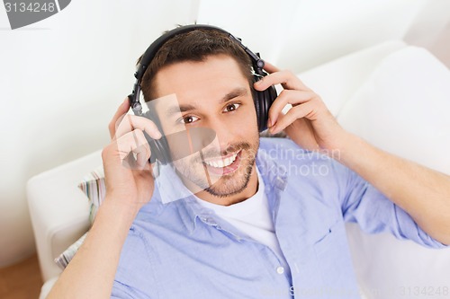 Image of smiling young man in headphones at home
