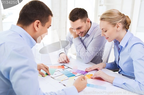 Image of smiling interior designers working in office