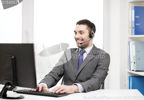 Image of helpline operator with headphones and computer