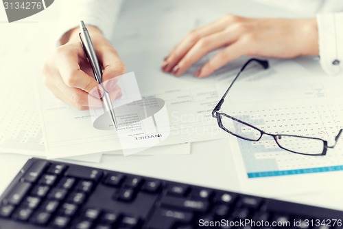 Image of woman hand filling in invoice paper