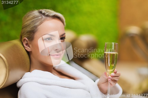 Image of beautiful young woman drinking champagne at spa