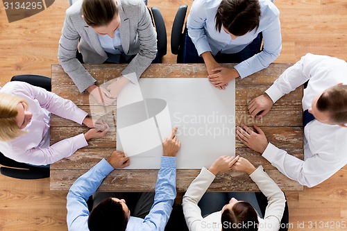 Image of close up of business team with paper at table