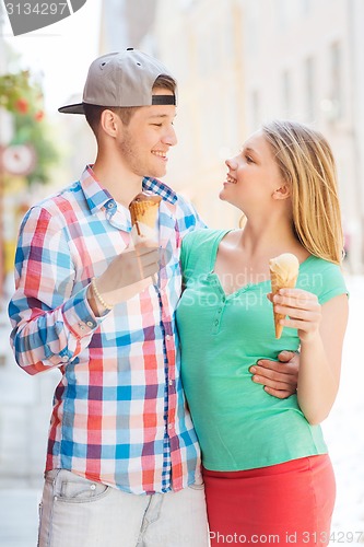 Image of smiling couple with ice-cream in city
