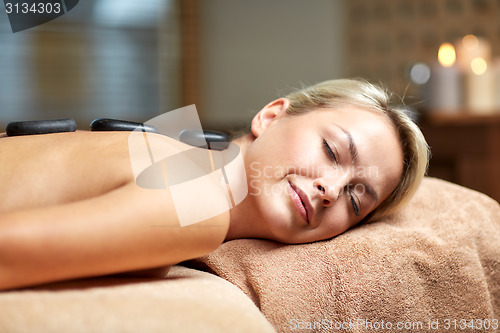 Image of close up of woman having hot stone massage in spa