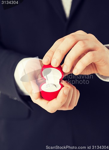 Image of man with gift box and wedding ring