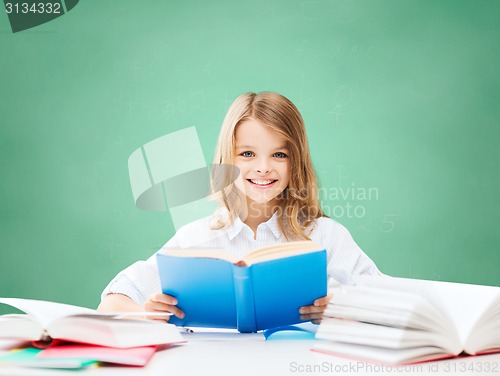 Image of happy student girl reading book at school