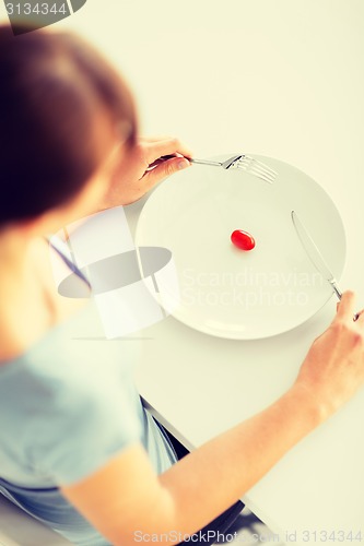 Image of woman with plate and one tomato