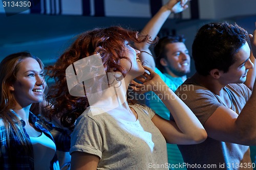 Image of happy friends dancing at night club