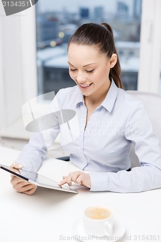 Image of smiling businesswoman with tablet pc in office