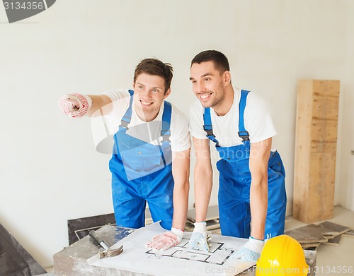 Image of group of builders with blueprint