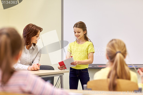 Image of group of school kids with teacher in classroom