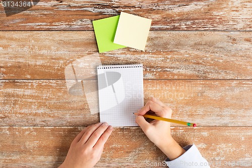 Image of close up of hands with notebook and stickers