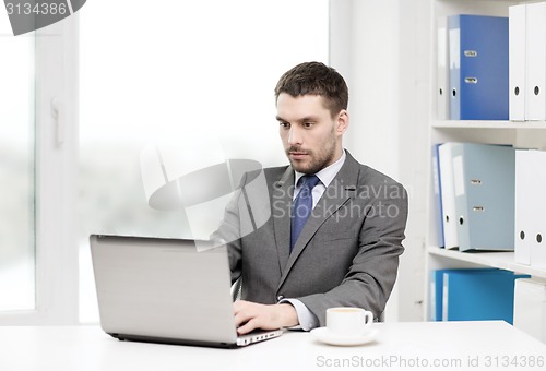 Image of busy businessman with laptop and coffee