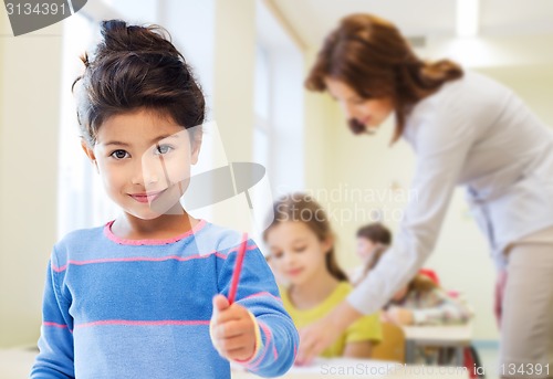 Image of happy little school girl over classroom background
