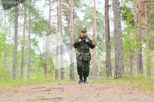 Image of young soldier with backpack in forest