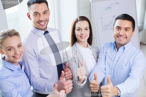 Image of smiling business people showing thumbs up