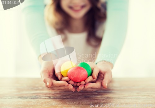 Image of close up of girl and mother holding colored eggs