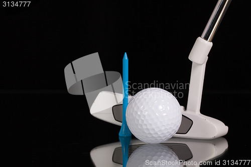 Image of Golf putter and gold equipments on the black glass desk