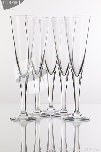Image of Five champagne glasses on a glass desk