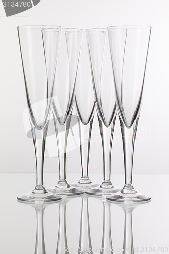 Image of Five champagne glasses on a glass desk