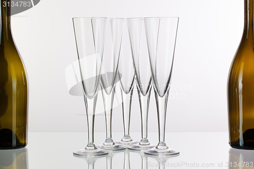 Image of Five champagne glasses on a glass desk