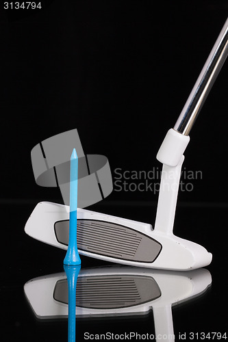 Image of Golf putter and gold equipments on the black glass desk