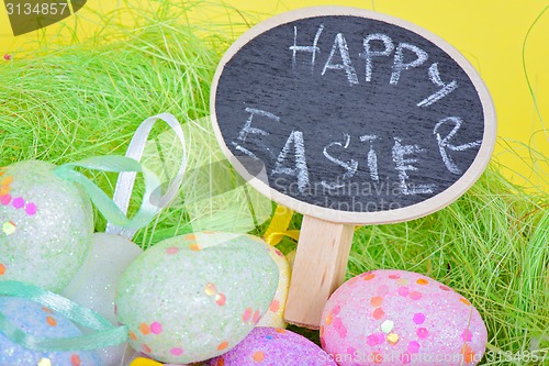 Image of Closeup ester eggs in nest with chalkboard