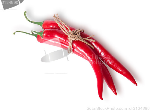 Image of Three red chili peppers tied with a rope top view