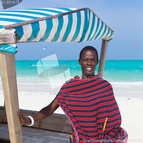 Image of Traditonaly dressed black man on beach. 