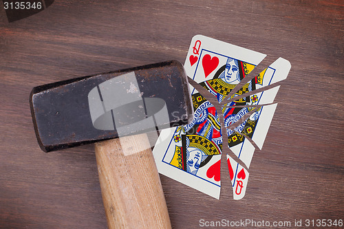 Image of Hammer with a broken card, queen of hearts