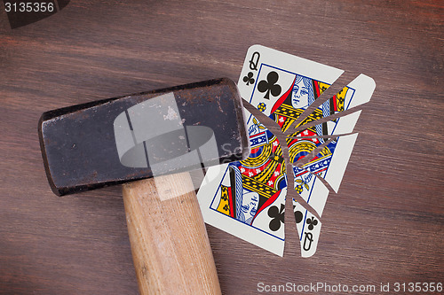 Image of Hammer with a broken card, queen of clubs