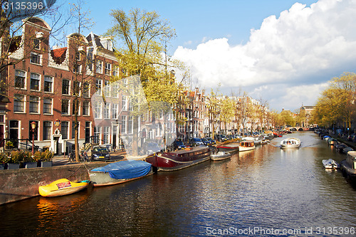 Image of Amsterdam canal with trees and small boats