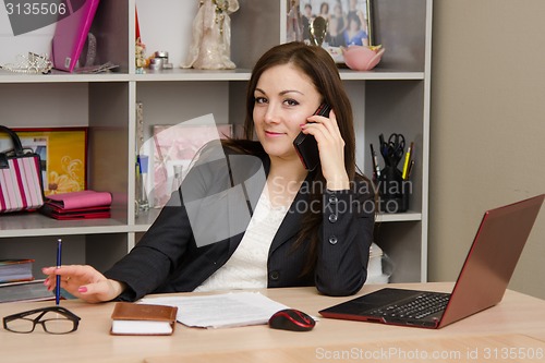 Image of employee of office talking on phone at your desk