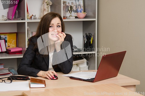Image of girl at computer nervously biting his nails