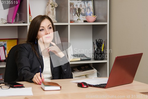 Image of Thoughtful girl in the office head table sits at computer and holds hand of person