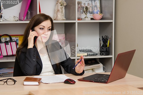 Image of employee of office is telephone conversation with a worried expression on his face