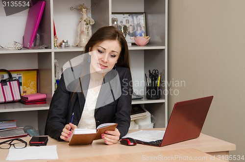 Image of Girl in the office angrily looks to notebook