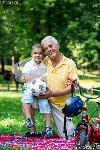 Image of grandfather and child have fun  in park