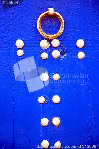 Image of rusty       nail dirty   in the blue wood door and morocco knock
