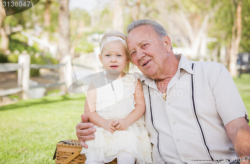 Image of Grandfather and Granddaughter Hugging Outside At The Park