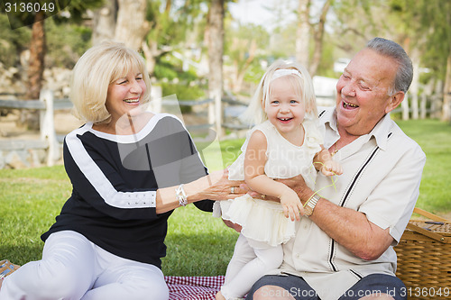 Image of Affectionate Granddaughter and Grandparents Playing At The Park