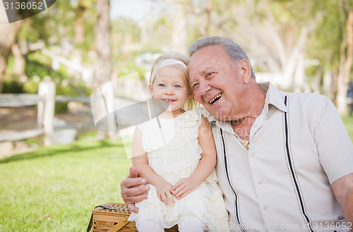 Image of Grandfather and Granddaughter Hugging Outside At The Park